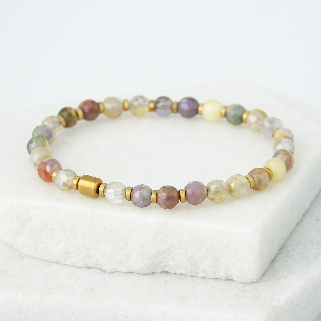 Beaded bracelet with gold accents on a white surface