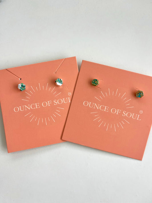 Pair of earrings on 'Ounce of Soul' branded cards against a white background